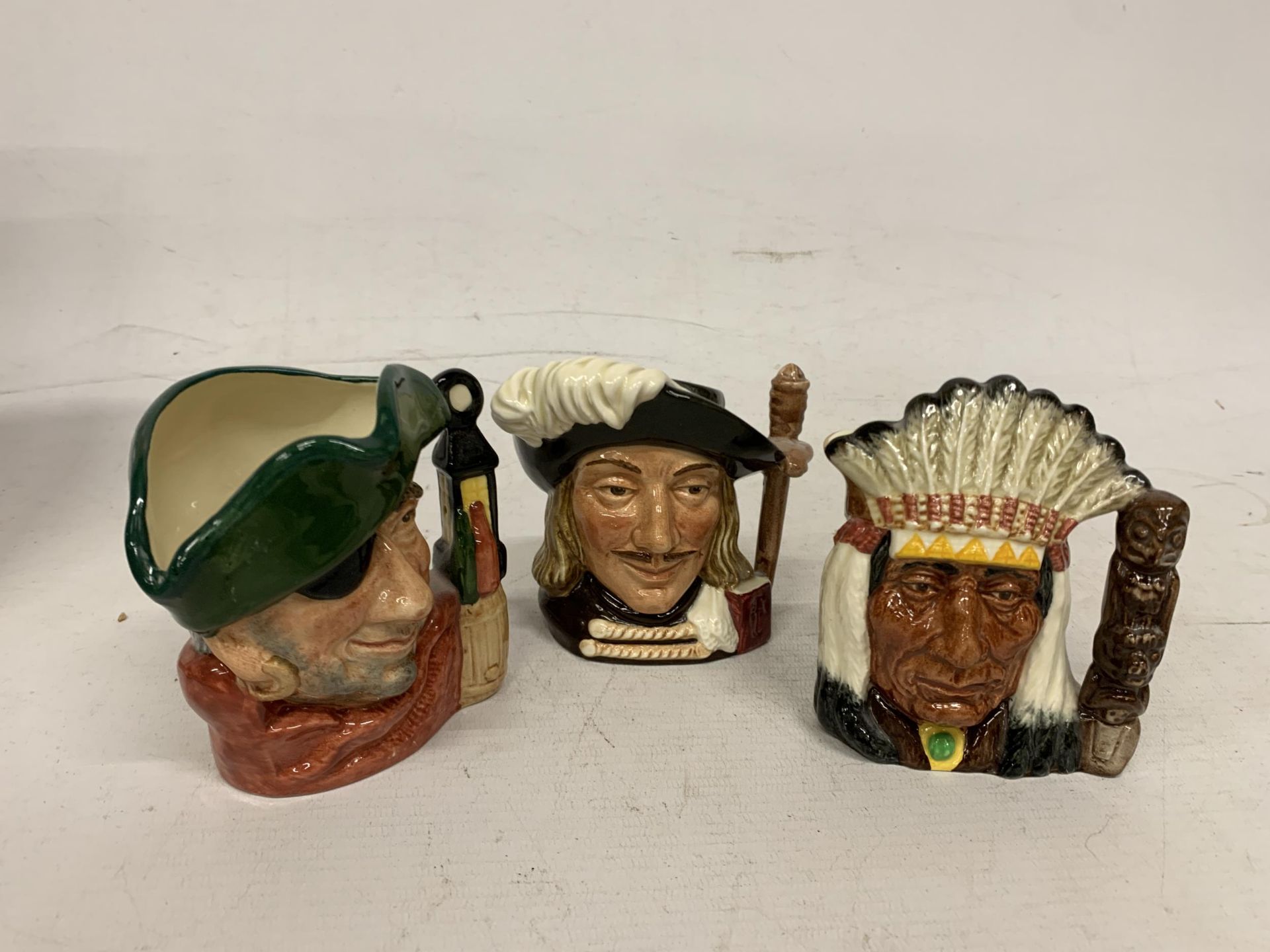 THREE ROYAL DOULTON TOBY JUGS TO INCLUDE THE SMUGGLER,NORTH AMERICAN INDIAN AND ARAMIS