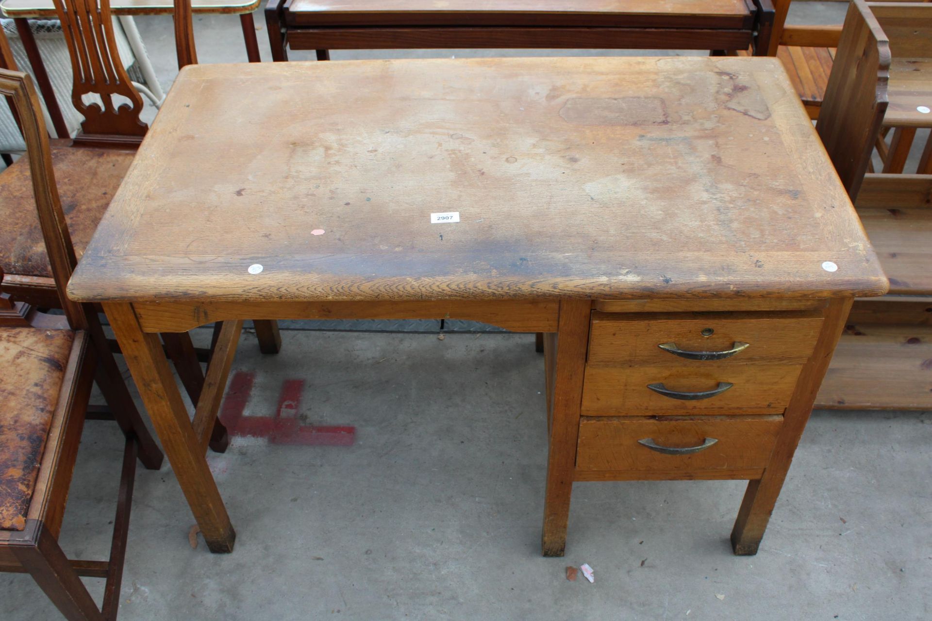 A MID 20TH CENTURY OAK SINGLE PEDESTAL DESK ENCLOSING THREE DRAWERS AND SLIDE 42" X 24"