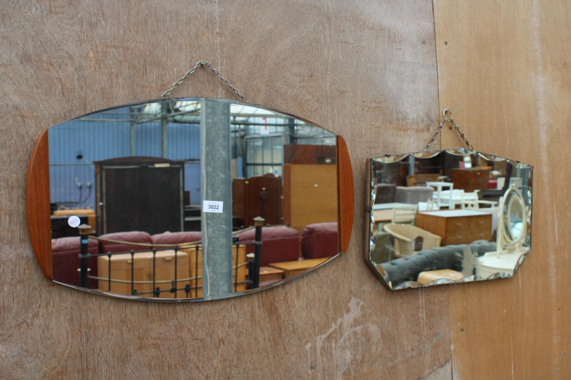 A RETRO WALL MIRROR WITH TEAK EDGES AND A FRAMELESS WALL MIRROR