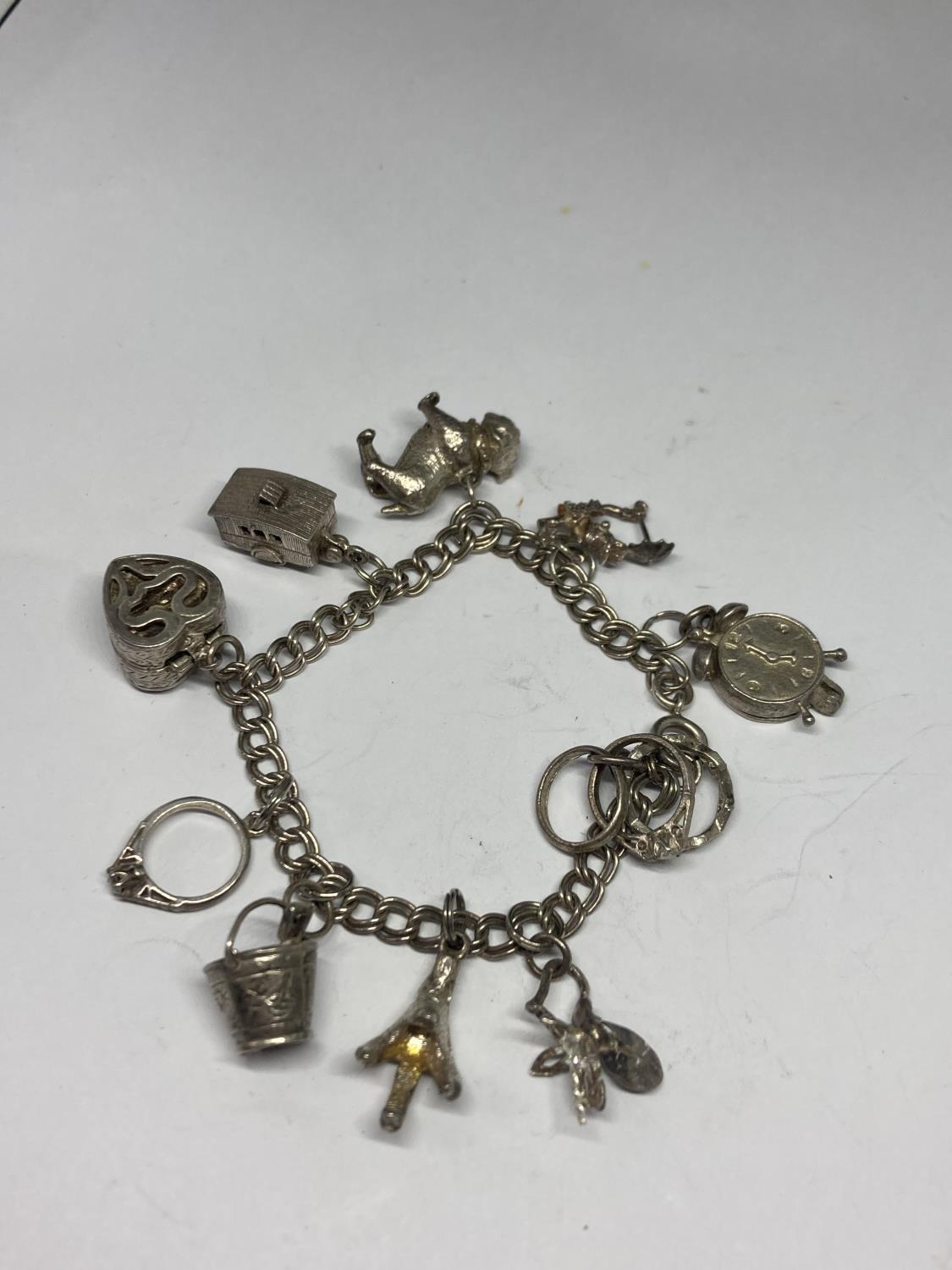 A SILVER CHARM BRACELET WITH TEN CHARMS