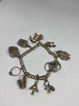 A SILVER CHARM BRACELET WITH TEN CHARMS