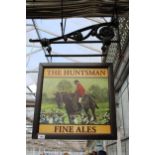 A DOUBLE SIDED WOODEN 'THE HUNTSMAN' PUB SIGN WITH CAST IRON WALL MOUNTING BRACKET