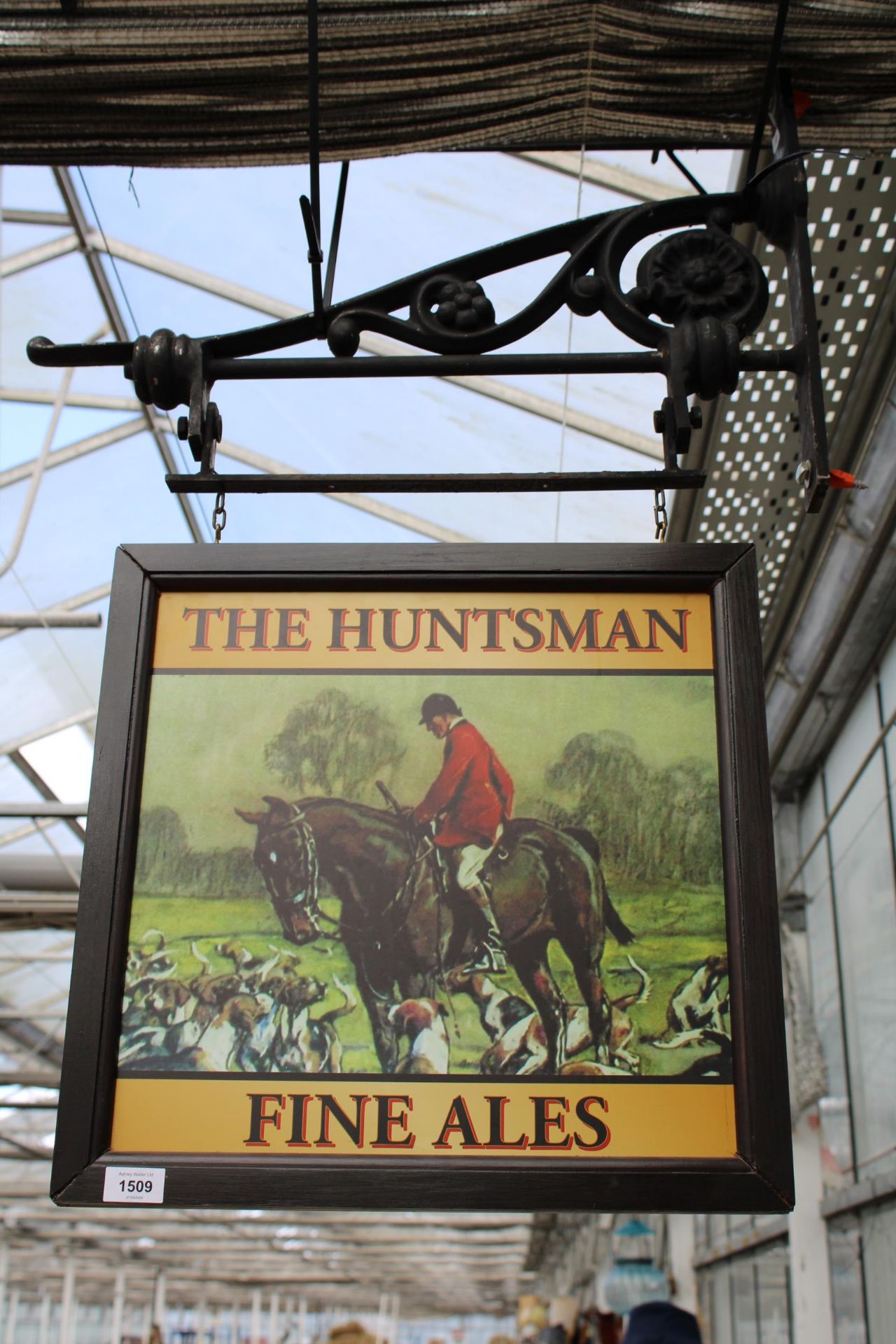A DOUBLE SIDED WOODEN 'THE HUNTSMAN' PUB SIGN WITH CAST IRON WALL MOUNTING BRACKET