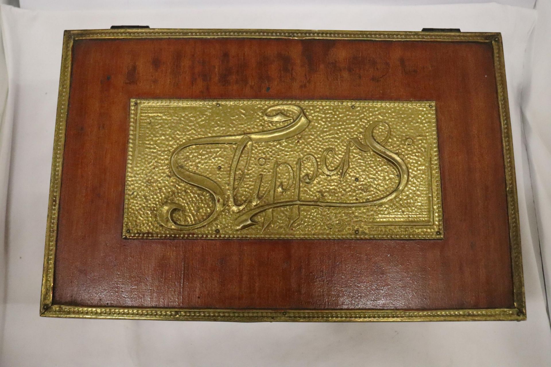 A WOOD AND BRASS VINTAGE SLIPPERS BOX
