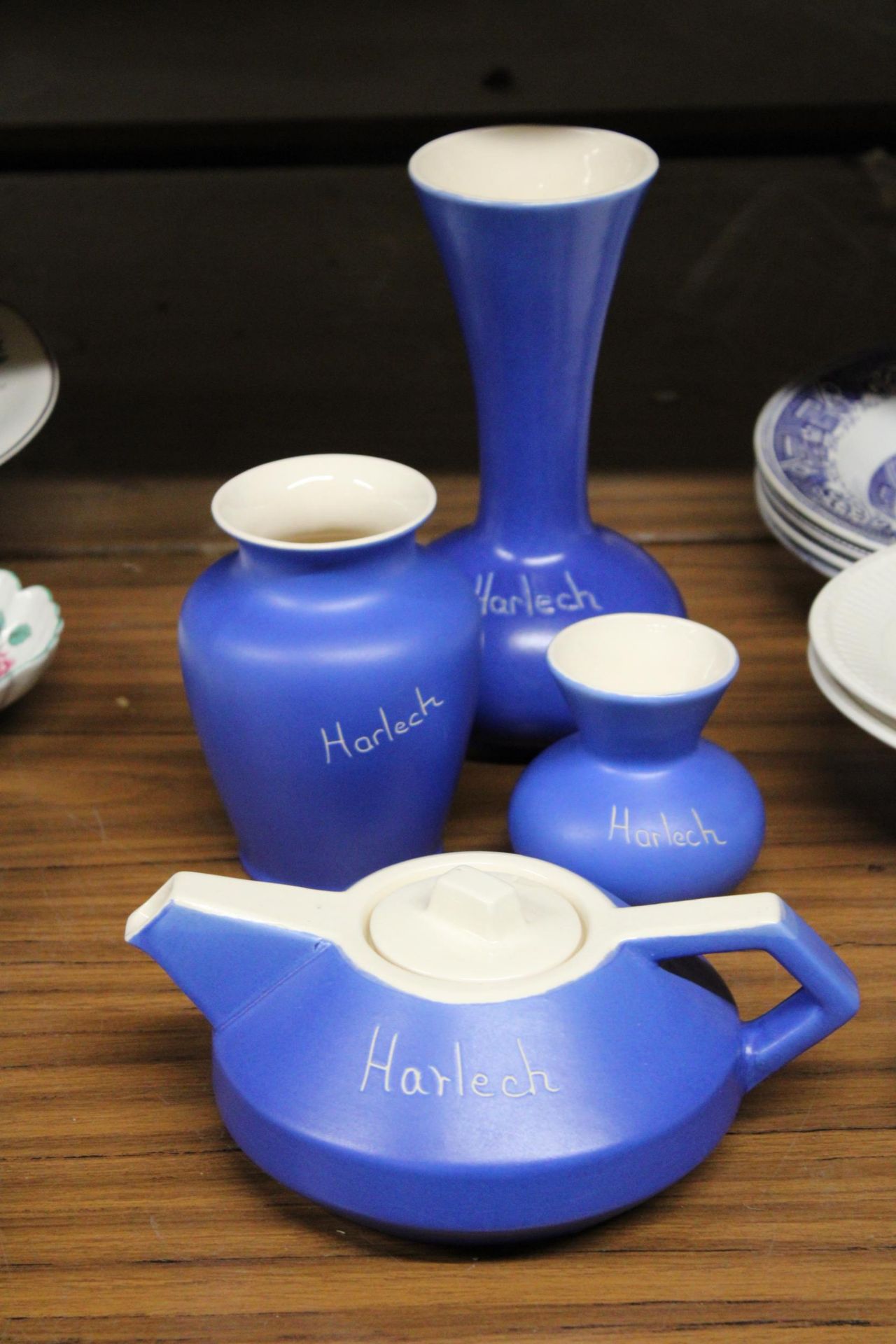 FOUR PIECES OF DEVONMOOR POTTERY WITH 'HARLECH' INSCRIPTION TO INCLUDE A TEAPOT AND THREE VASES