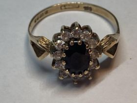 A 9 CARAT GOLD RING WITH A CENTRE SAPPHIRE SURROUNDED BY CUBIC ZIRCONIAS SIZE P/Q