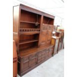 AN OAK OLD CHARM LOUNGE UNTI WITH GLAZED AND LEADED LINEN FOLD DOORS WITH CUPBOARDS AND DRAWERS TO