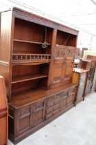AN OAK OLD CHARM LOUNGE UNTI WITH GLAZED AND LEADED LINEN FOLD DOORS WITH CUPBOARDS AND DRAWERS TO