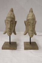 TWO BUDDAH HEADS ON STANDS, HEIGHT 27CM