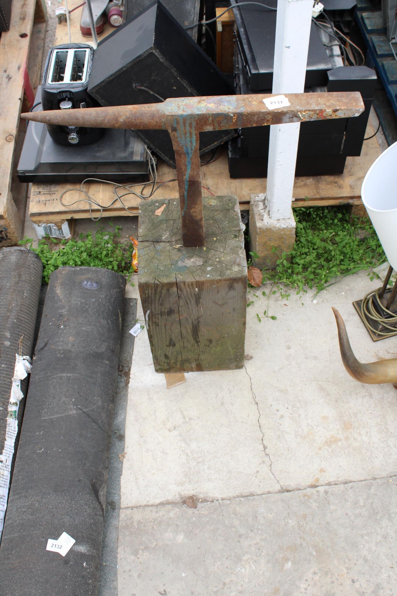 A SMALL ANVIL WITH WOODEN BLOCK BASE