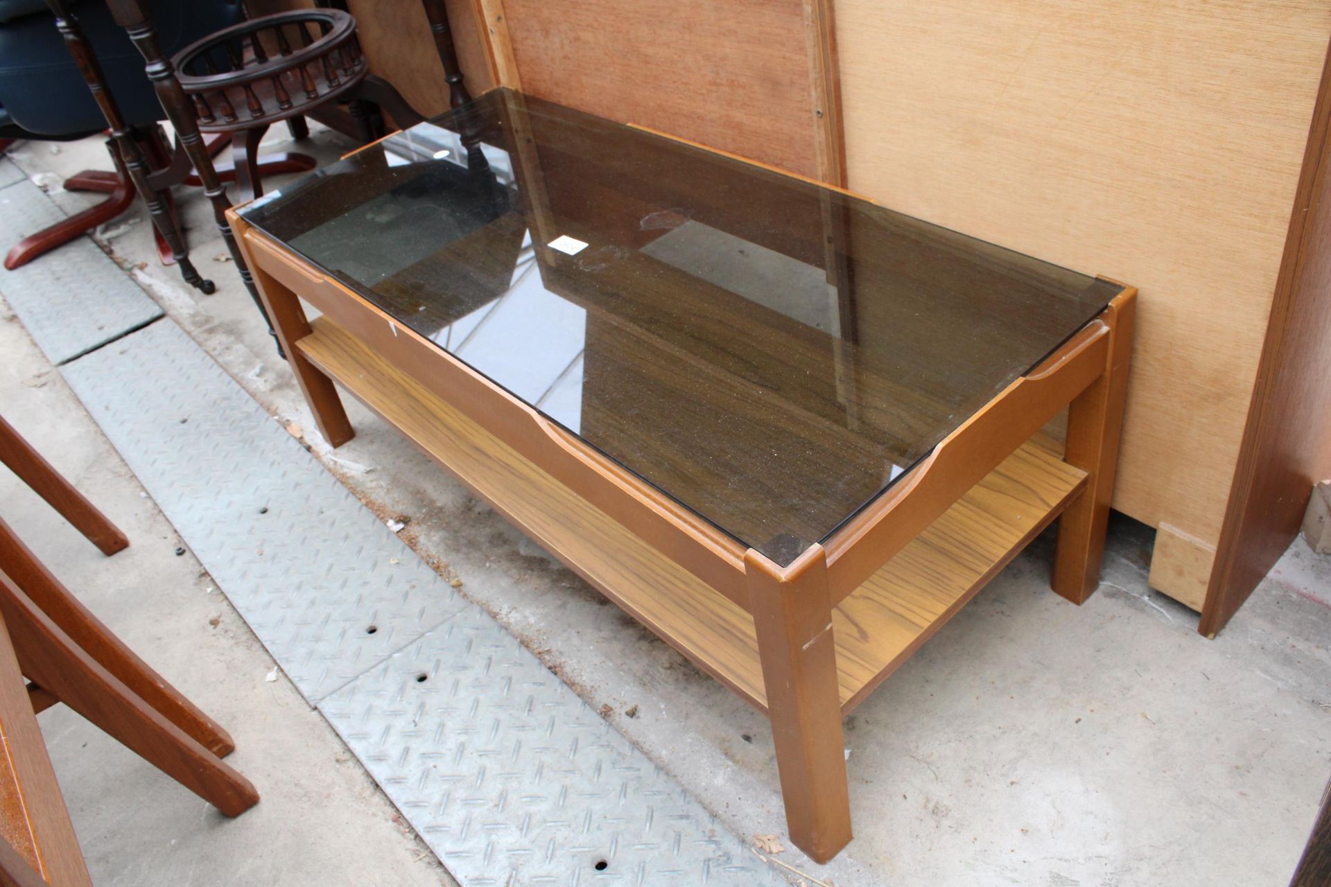 A RETRO TEAK TWO TIER COFFEE TABLE WITH SMOKED GLASS TOP