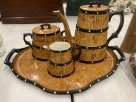 A CERAMIC TEASET ON A TRAY TO INCLUDE A COFFEE POT, SUGAR BOWL AND CREAM JUG, IN A BARREL STYLE