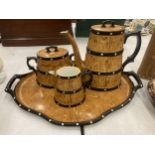A CERAMIC TEASET ON A TRAY TO INCLUDE A COFFEE POT, SUGAR BOWL AND CREAM JUG, IN A BARREL STYLE