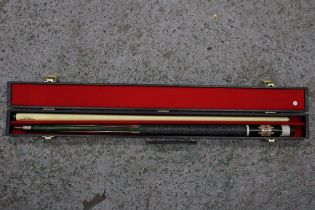 A DECORATIVE POOL CUE IN A HARD CASE