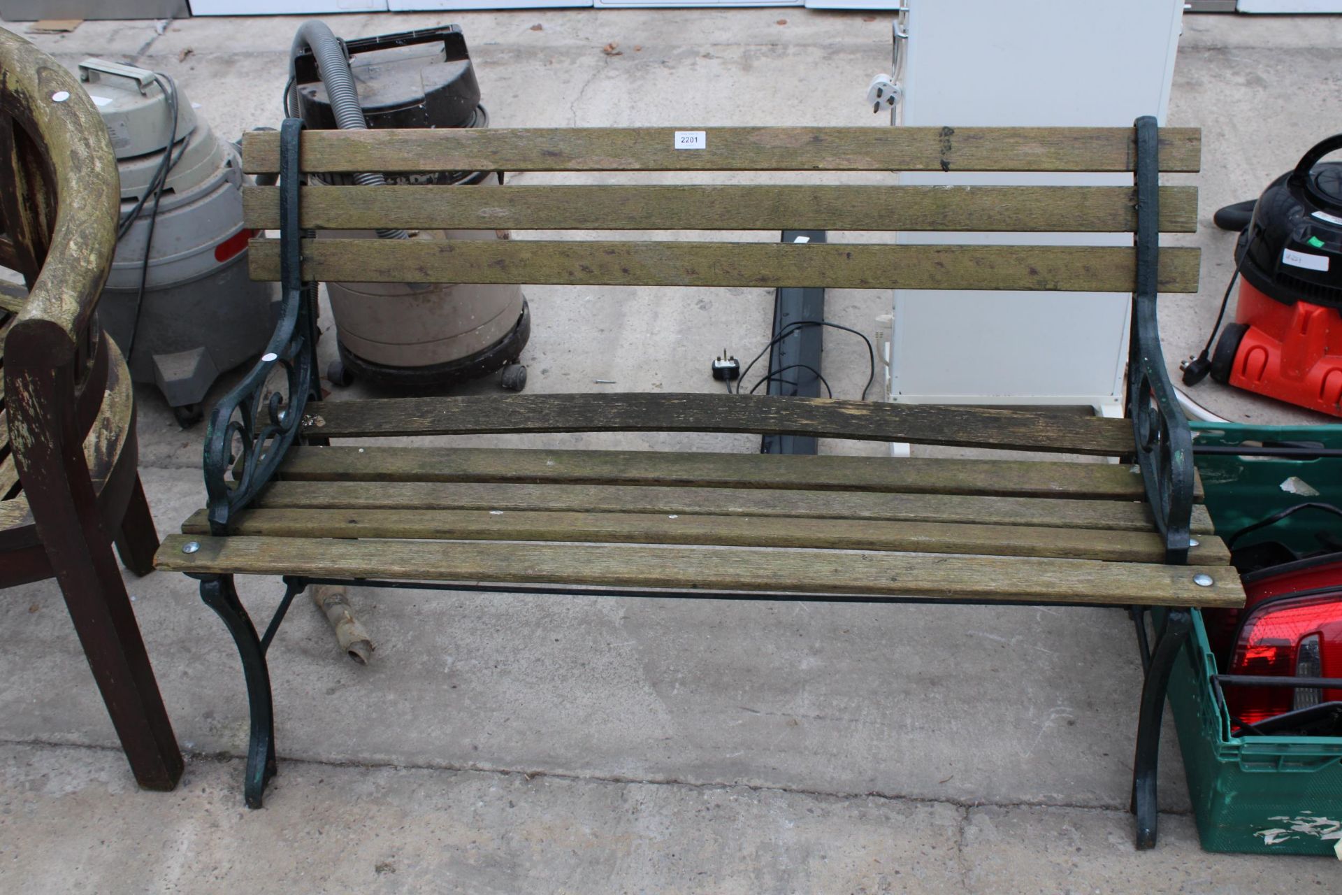 A WOODEN SLATTED GARDEN BENCH WITH CAST ENDS