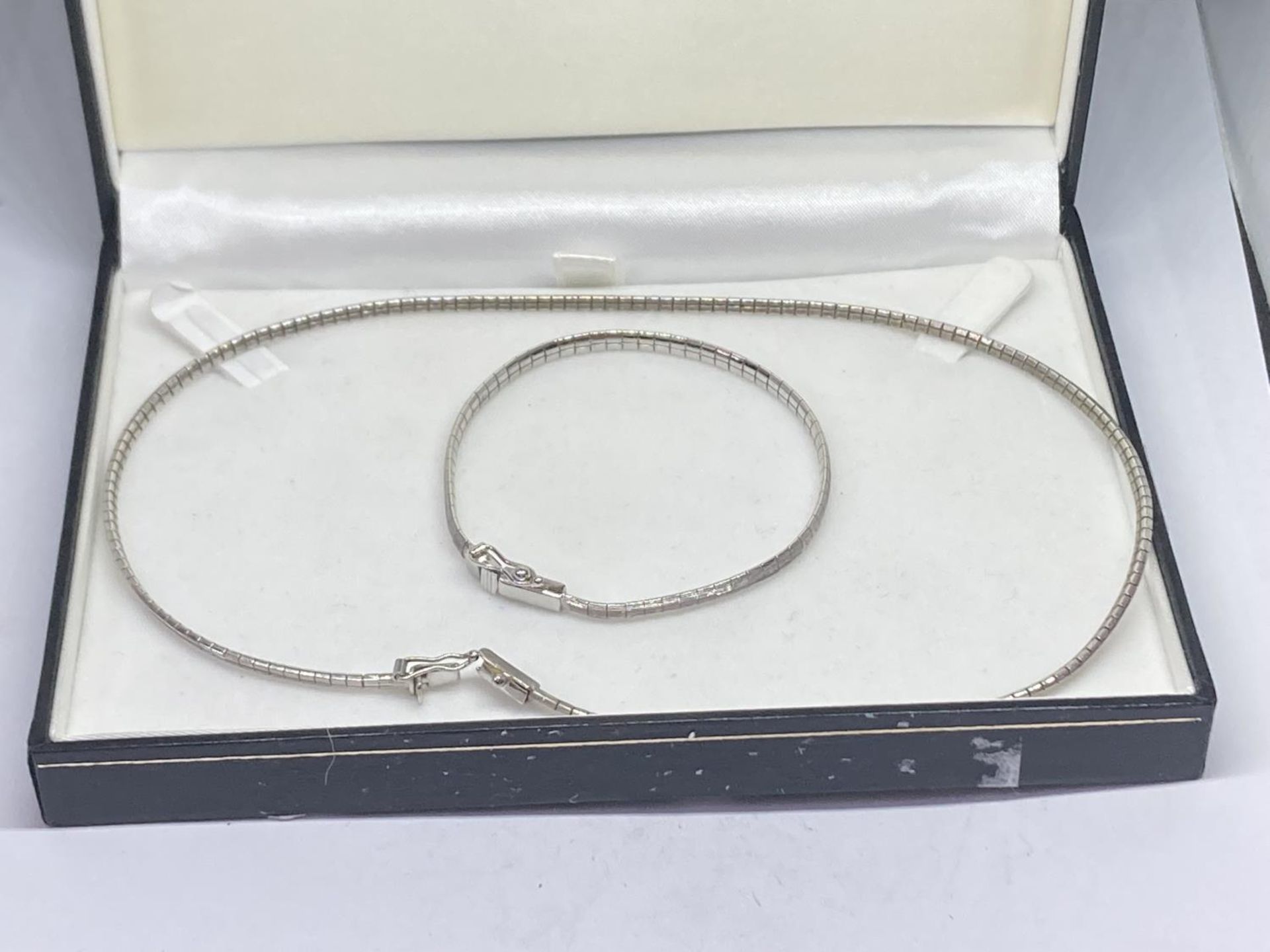 A SILVER NECKLACE AND MATCHING BRACELET IN A PRESENTATION BOX