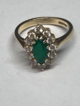 A 9 CARAT GOLD RING WITH A CENTRE EMERALD SURROUNDED BY CUBIC ZIRCONIAS SIZE L
