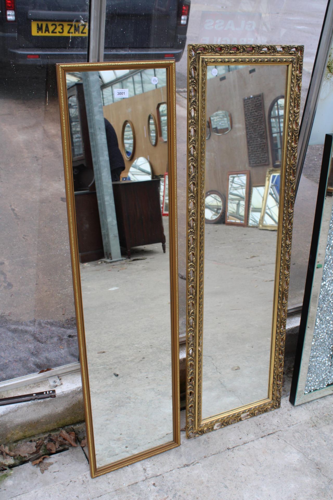 A GILT FRAMED WALL MIRROR 50" X 16" AND A SMALLER MIRROR