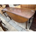 A VICTORIAN OVAL MAHOGANY DROP LEAF DINING TABLE ON CABRIOLE SUPPORTS