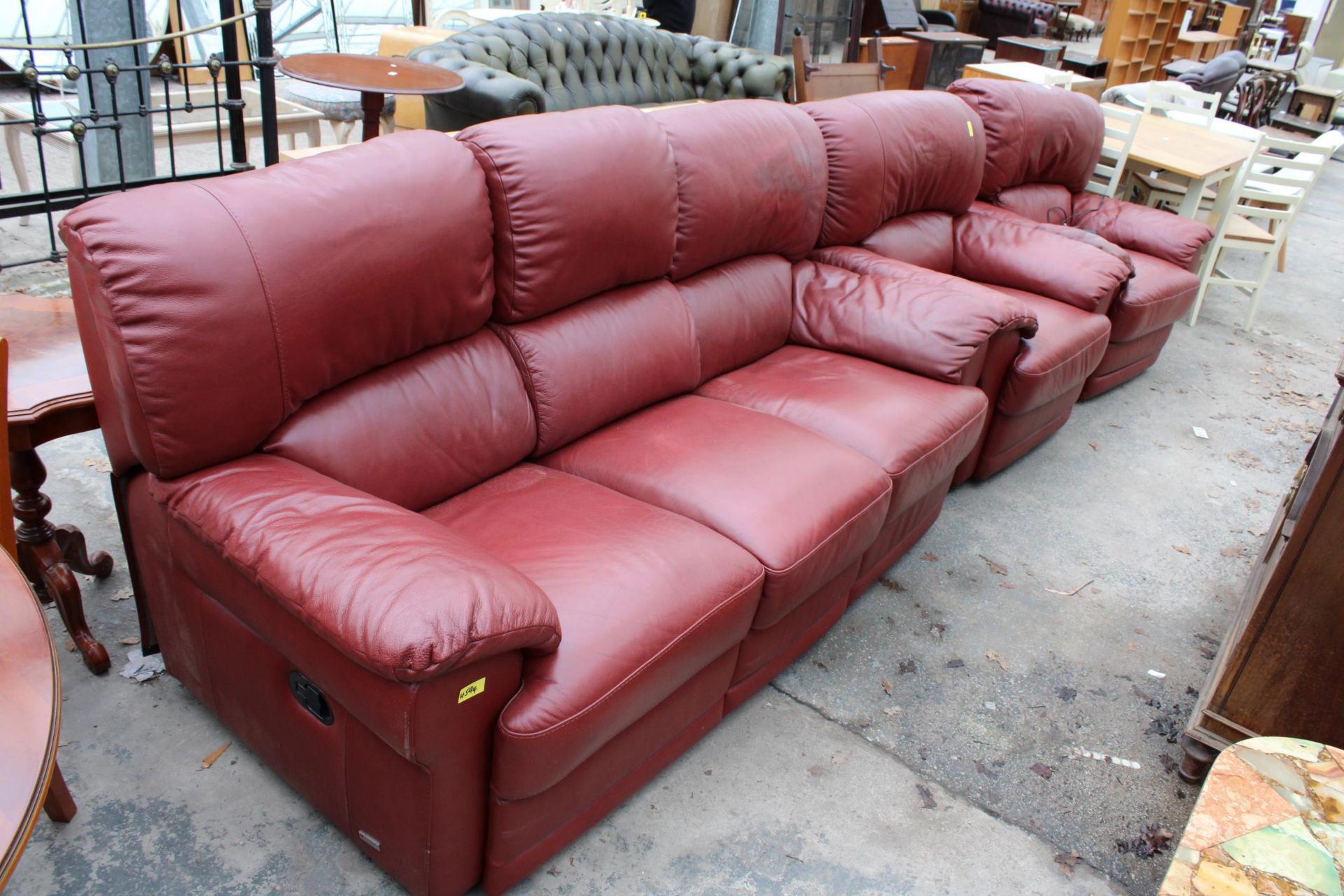 A RED LEATHER VIOLINO THREE PIECE SUITE COMPRISING OF A THREE SEATER SETTEE, EASY CHAIR AND AN