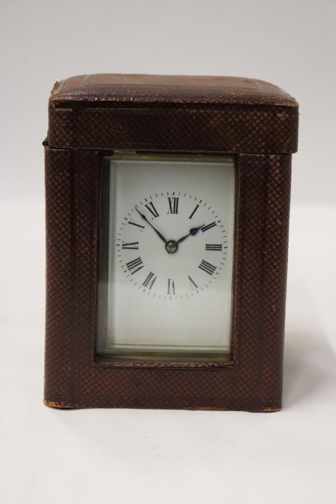 A VINTAGE BRASS ALARM CLOCK WITH GLASS SIDES TO SHOW INNER WORKINGS, IN A LEATHER CASE