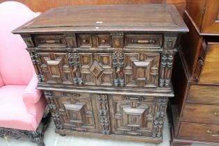 AN OAK CHARLES I STYLE CHEST OF DRAWERS WITH CUPBOARD TO BASE ENCLOSING TWO NINE BOTTLE