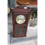 AN OAK CASED CHIMING WALL CLOCK