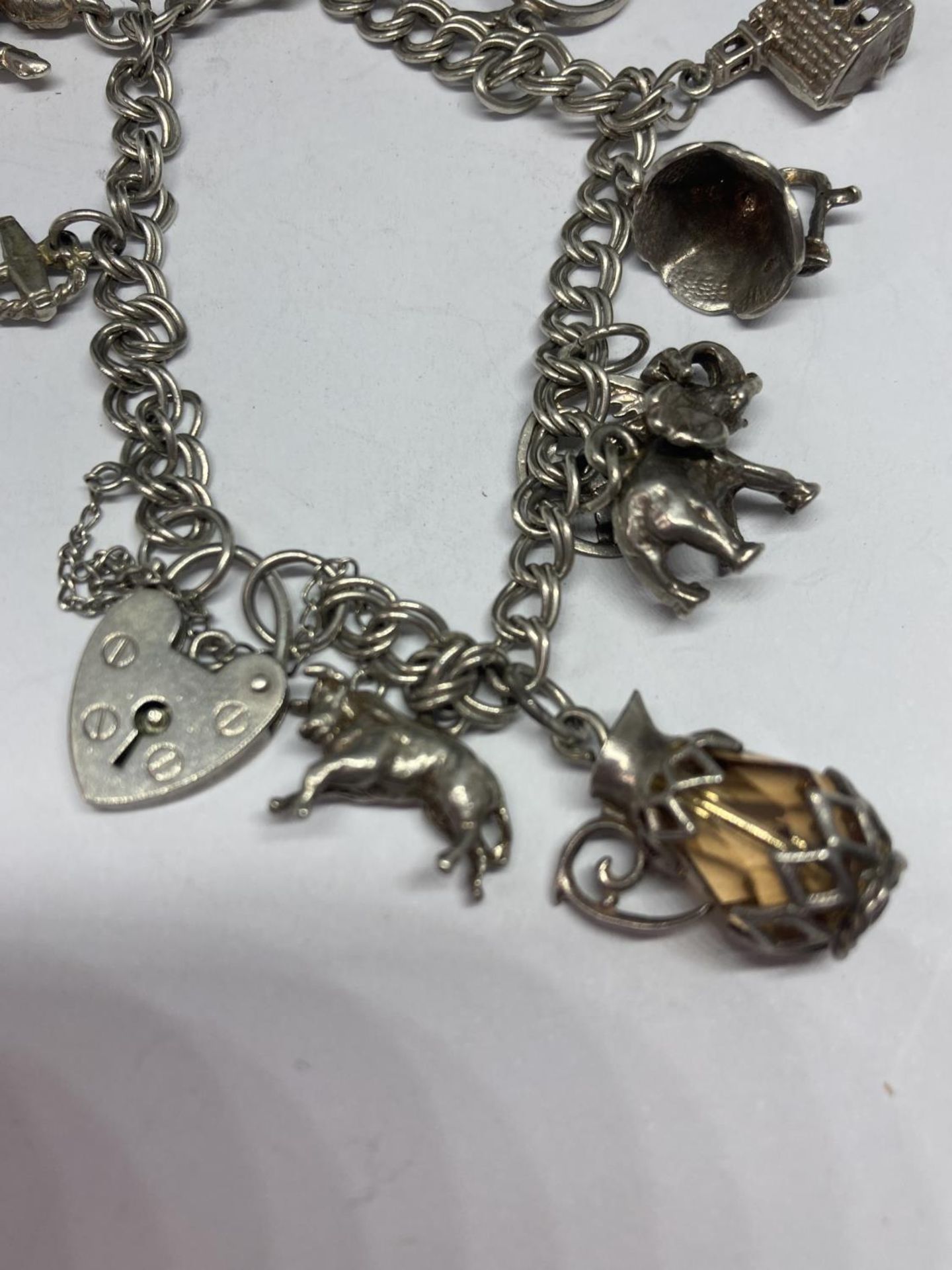 A SILVER CHARM BRACELET WITH TEN CHARMS AND A HEART PADLOCK - Image 4 of 4