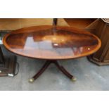 AN OVAL MAHOGANY INLAID AND CROSSBANDED COFFEE TABLE ON PEDESTAL BASE WITH BRASS CLAW FEET AND