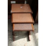 A RETRO TEAK G PLAN NEST OF THREE TABLES WITH EMBOSSED COPPER TOPS