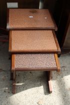 A RETRO TEAK G PLAN NEST OF THREE TABLES WITH EMBOSSED COPPER TOPS