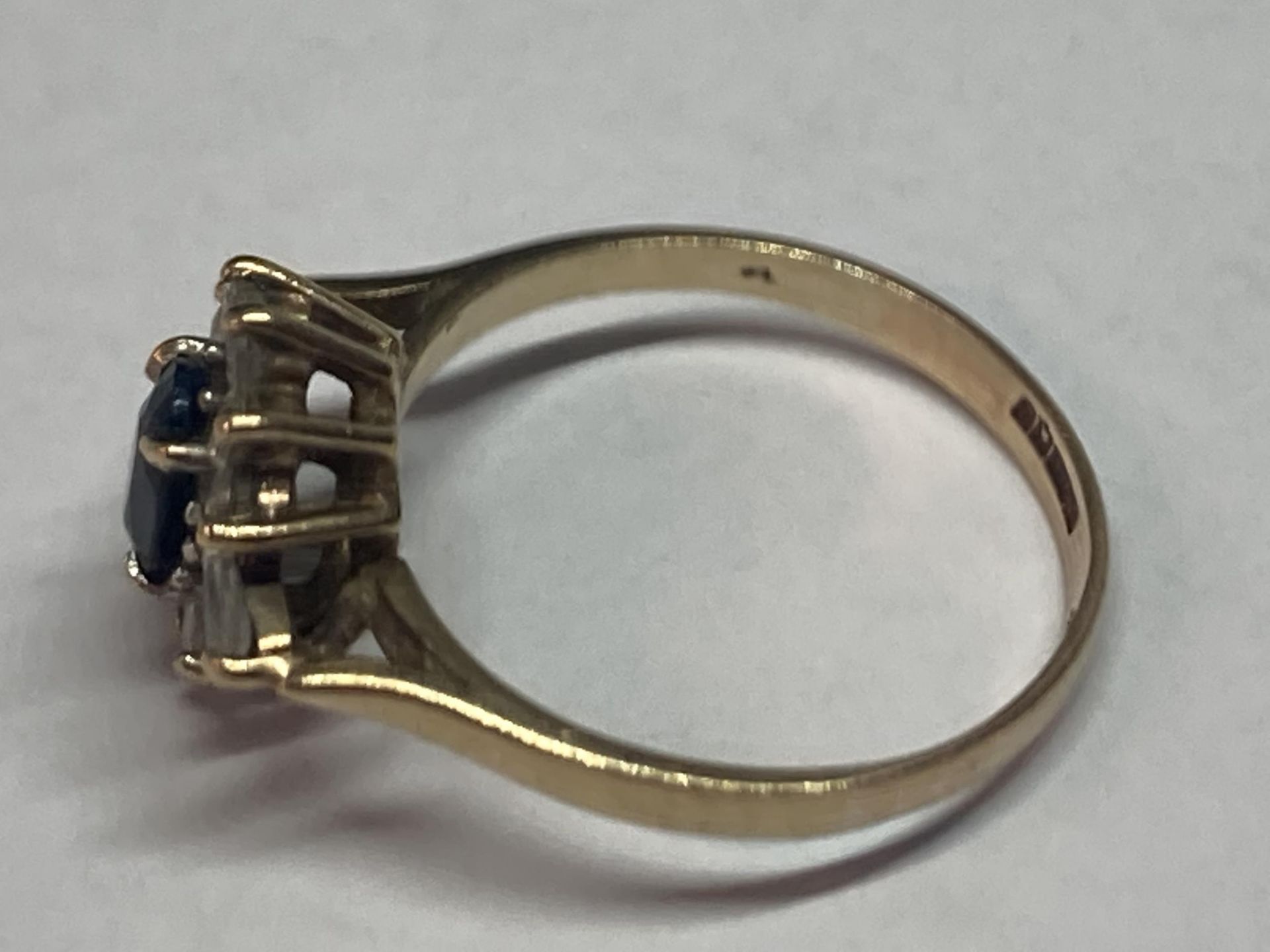 A 9 CARAT GOLD RING WITH A CENTRE SAPPHIRE SURROUNDED BY CUBIC ZIRCONIAS SIZE M - Image 2 of 3