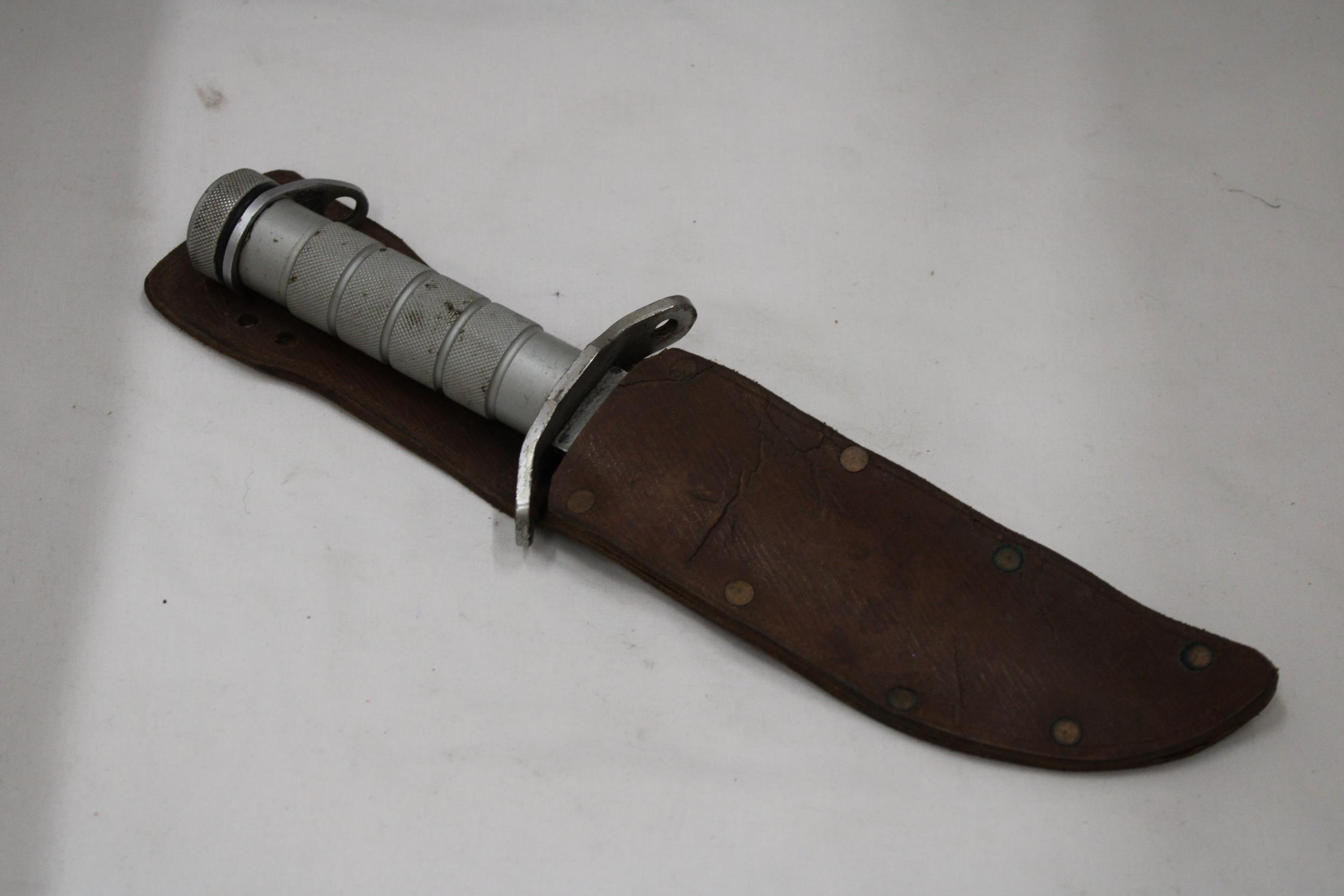 A RAMBO KNIFE IN A LEATHER SHEATH