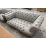 A LEATHER CHESTERFIELD STYLE BUTTON BACK THREE-SEATER SETTEE ON TURNED LEGS