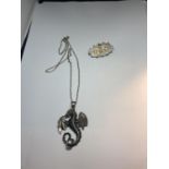 A SILVER NECKLACE WITH AN AMPHIPTERE PENDANT AND A VINTAGE SILVER BROOCH WITH FLORAL DECORATION