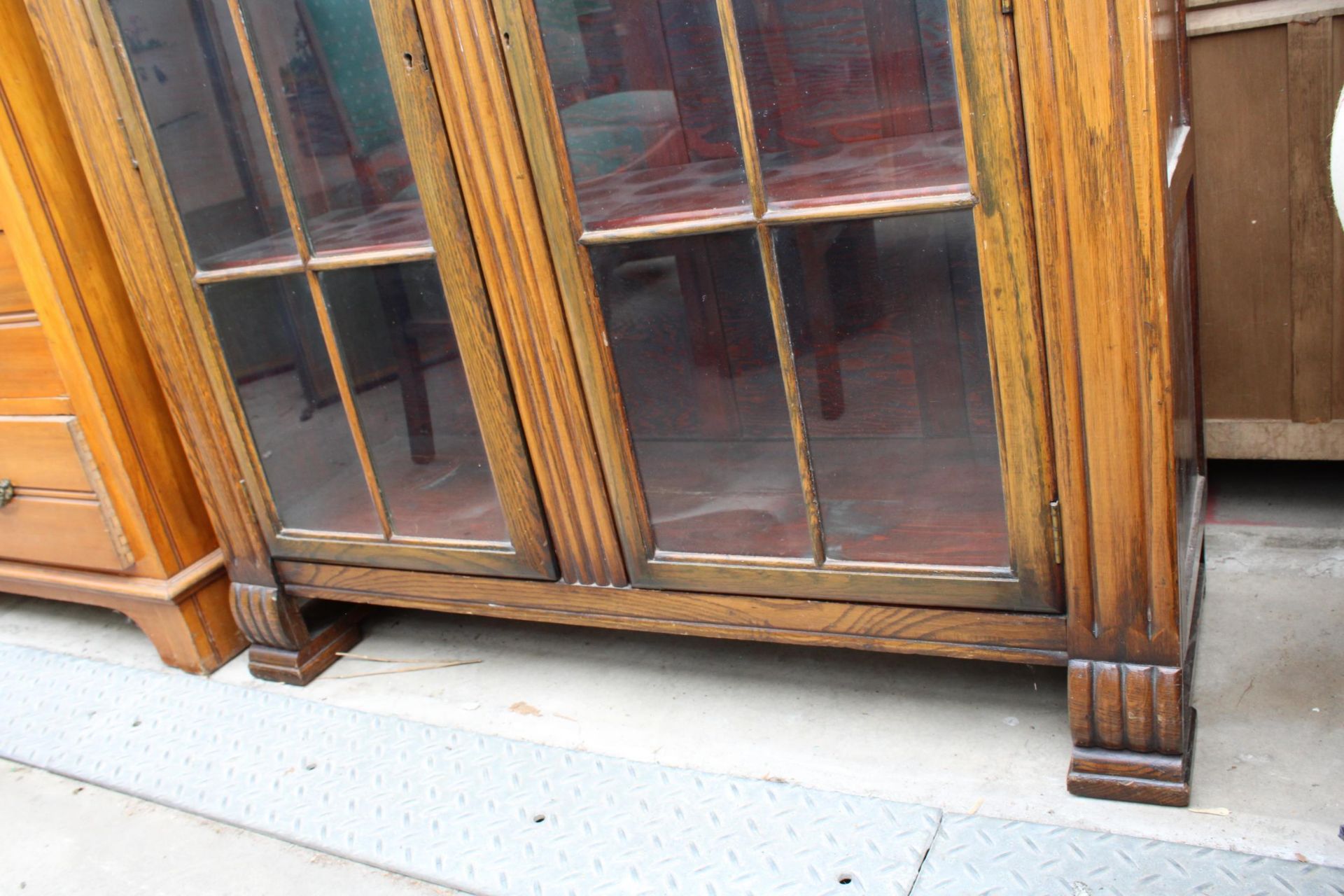 AN EARLY 20TH CENTURY OAK TWO DOOR GLAZED BOOKCASE, 42" WIDE - Image 2 of 3