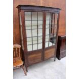 AN EARLY 20TH CENTURY MAHOGANY TWO DOOR DISPLAY CABINET WITH CUPBOARDS TO BASE ON TAPERING LEGS WITH
