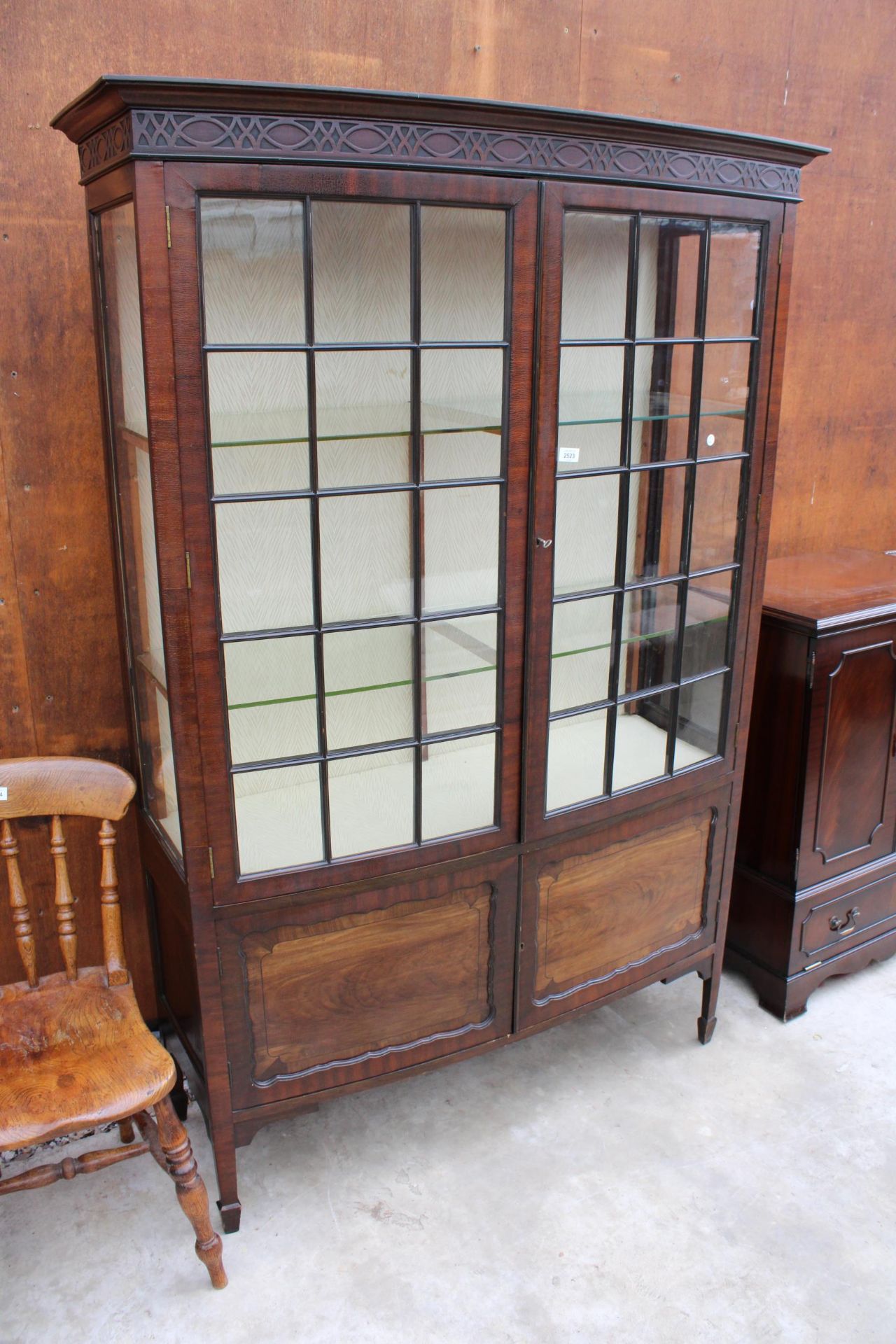 AN EARLY 20TH CENTURY MAHOGANY TWO DOOR DISPLAY CABINET WITH CUPBOARDS TO BASE ON TAPERING LEGS WITH