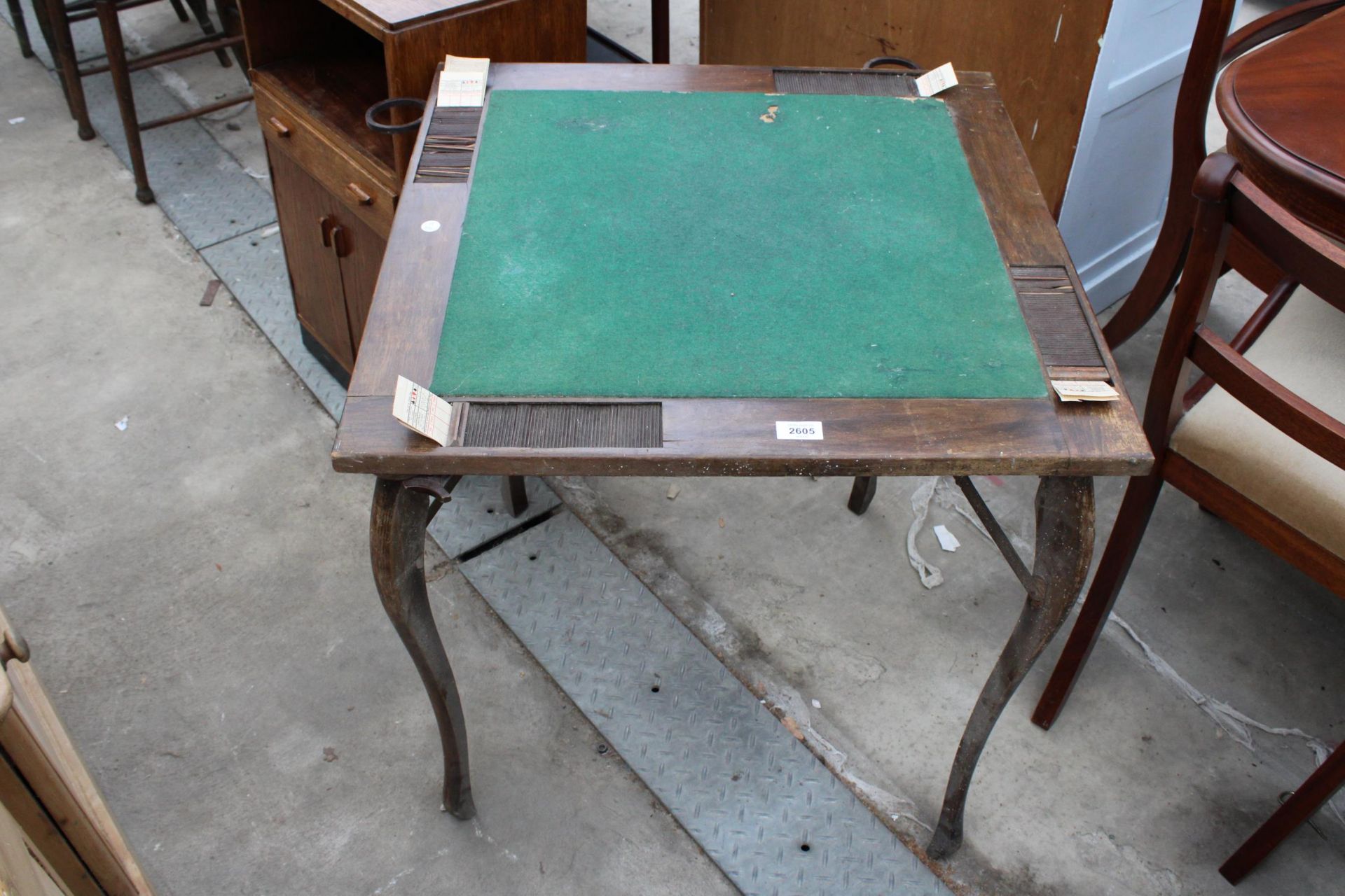 AN EARLY 20TH CENTURY FOLDING CARD TABLE WITH BAKALITE FOLD AWAY GLASS HOLDERS AND TAMBOUR SCORE