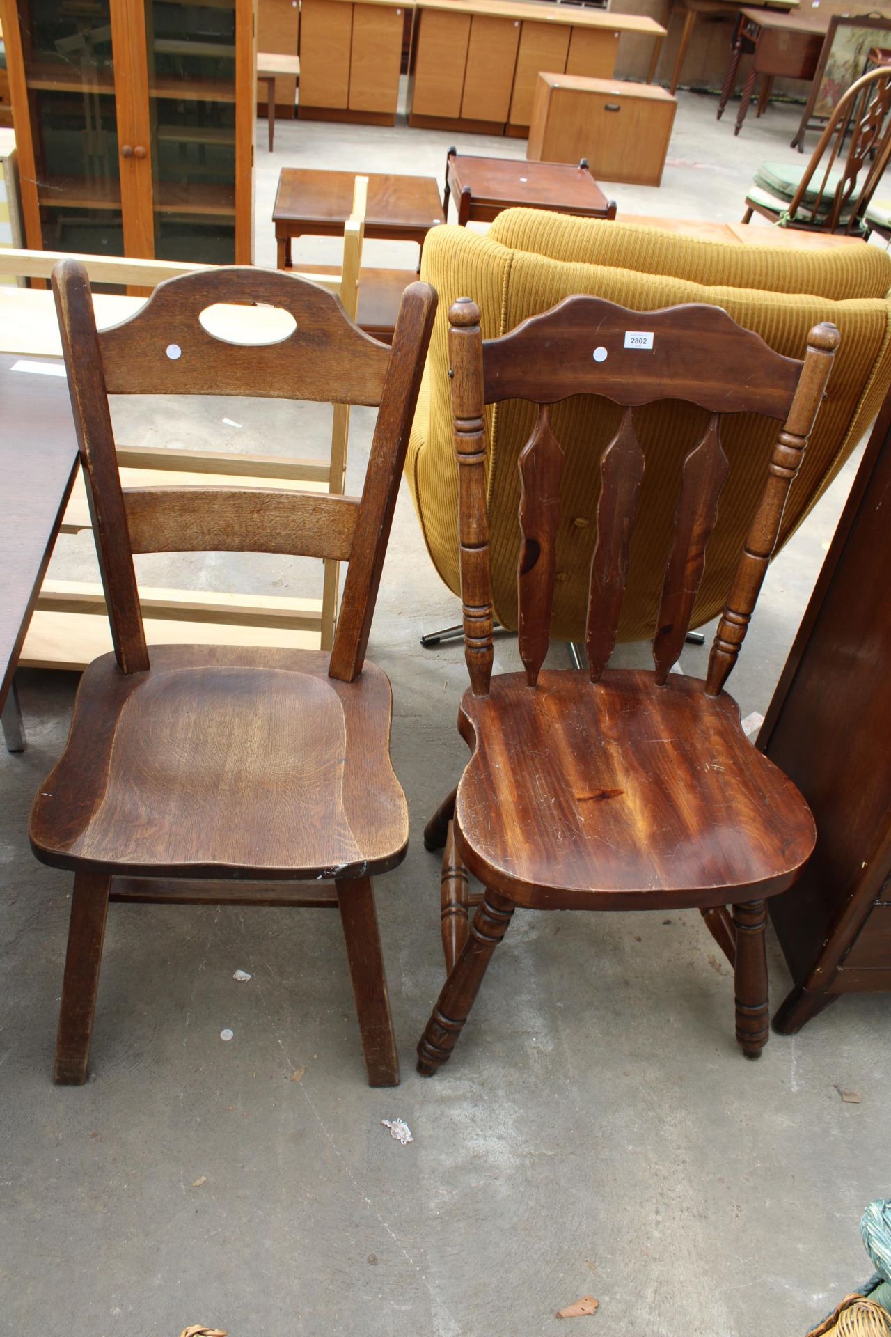 A MID TWENTIETH CENTURY OAK LADDER BACK CHAIR AND HARDWOOD KITCHEN CHAIR