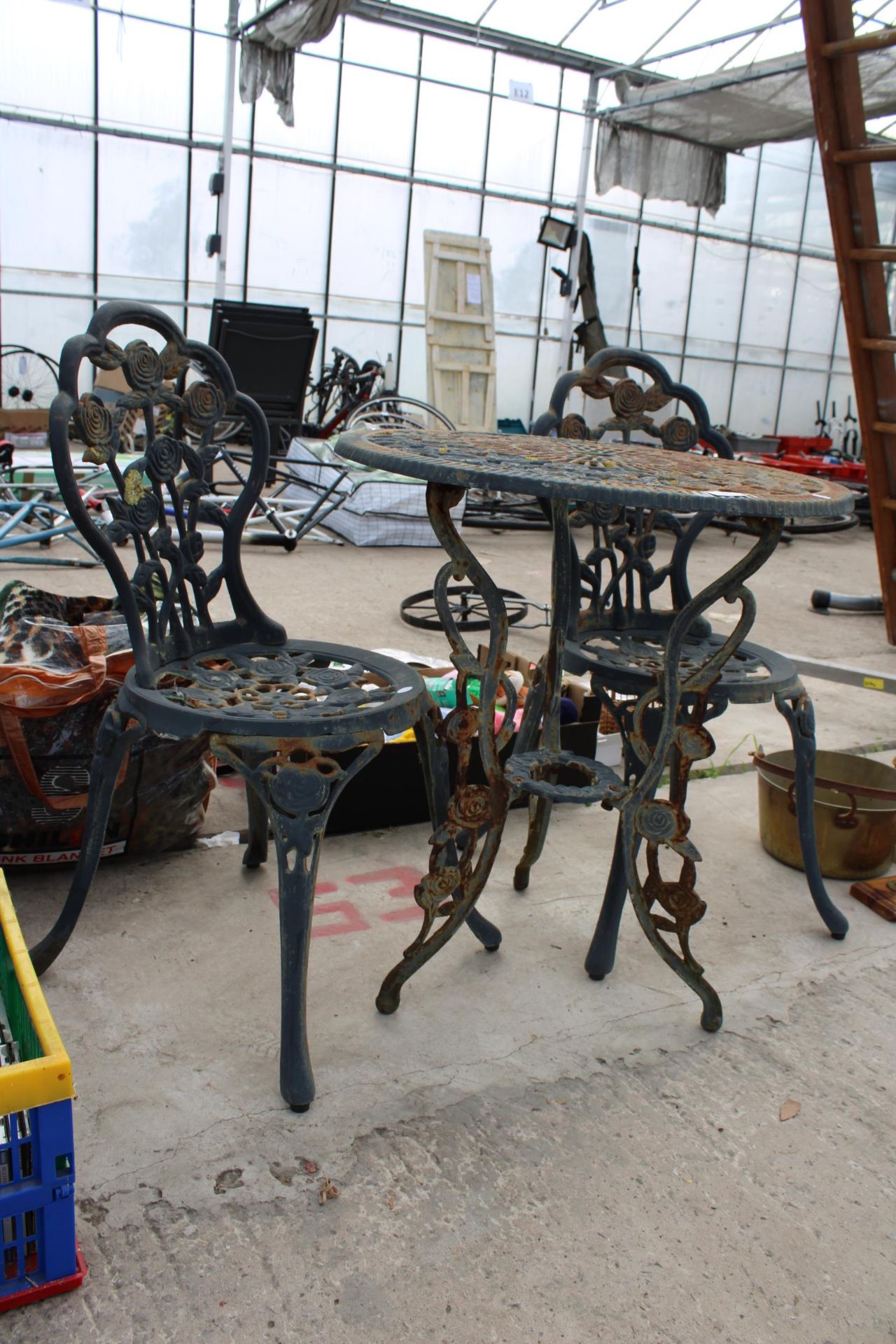 A VINTAGE STYLE CAST METAL BISTRO SET COMPRISING OF A ROUND TABLE AND TWO CHAIRS - Image 2 of 3