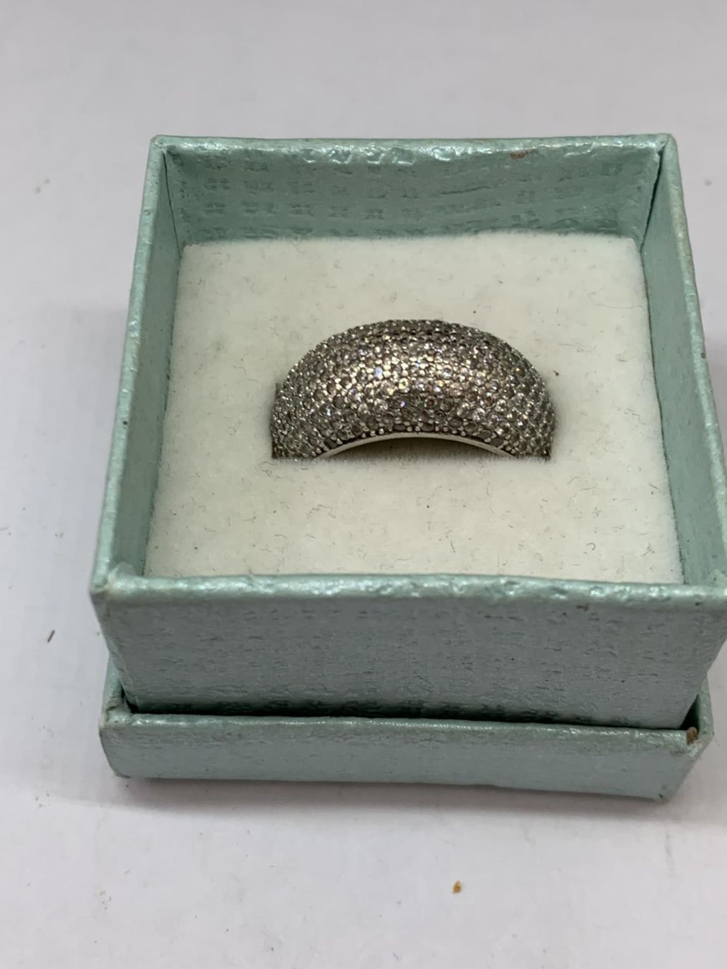 A SILVER RING IN A PRESENTATION BOX