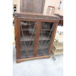 AN EARLY 20TH CENTURY OAK TWO DOOR GLAZED BOOKCASE, 36" WIDE