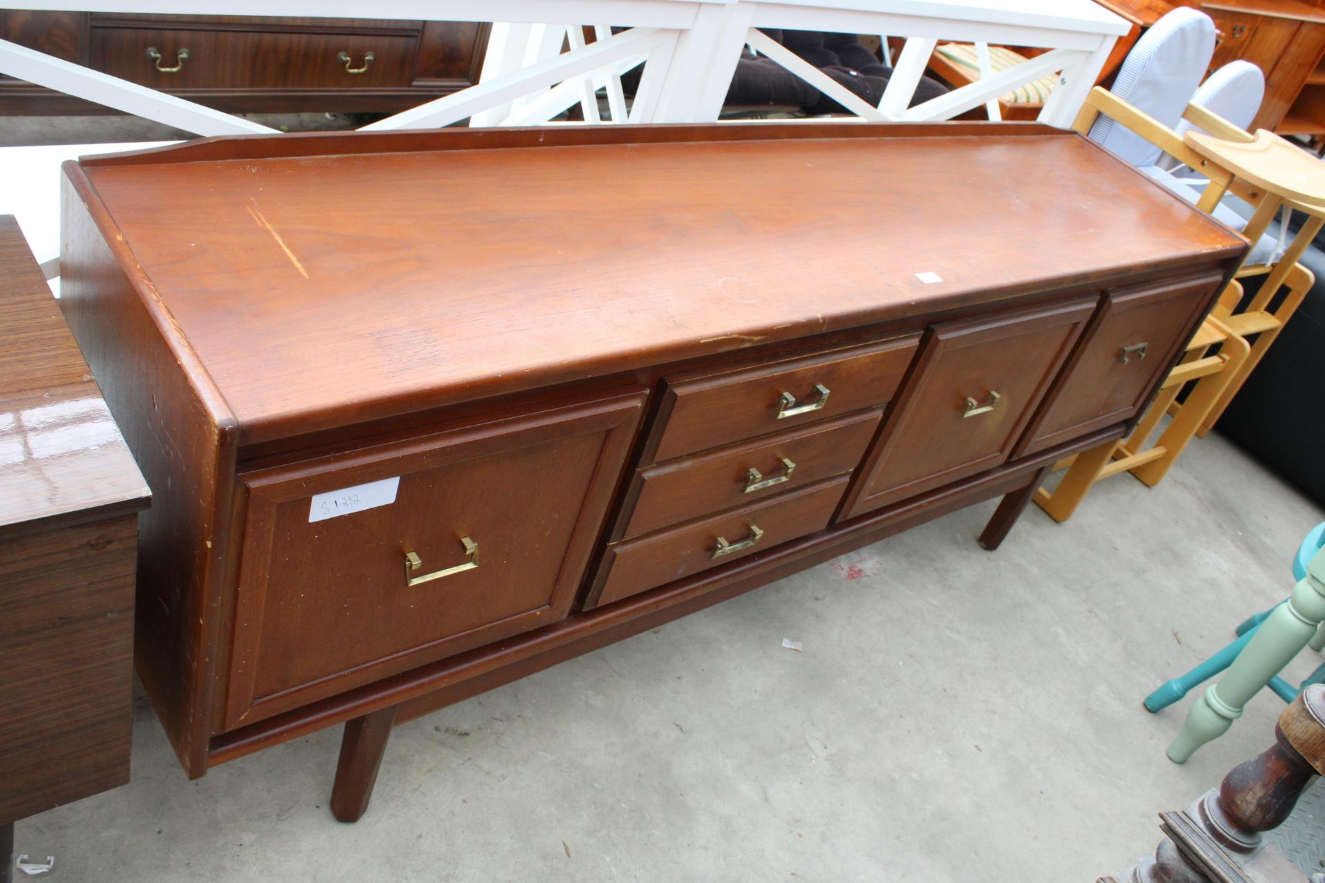 A RETRO TEAK SIDEBOARD ENCLOSING THREE DRAWERS AND THREE CUPBOARDS, 78" WIDE