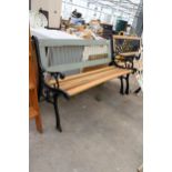 A WOODEN SLATTED GARDEN BENCH WITH DECORATIVE CAST BENCH ENDS