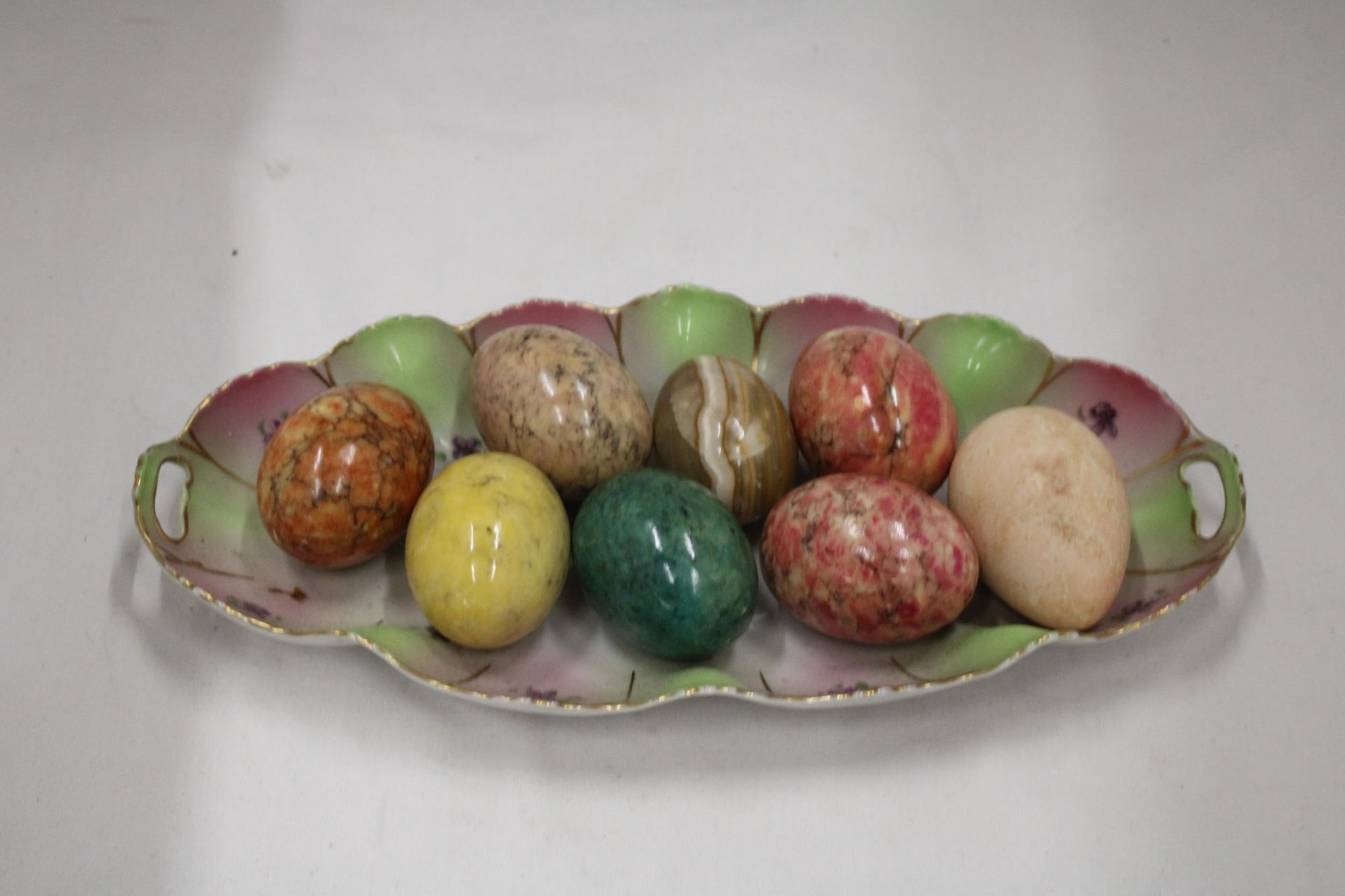 A COLLECTION OF 8 COLOURED MARBLE STYLE EGGS