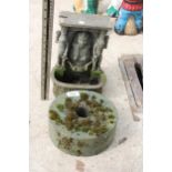 A SMALL GRIND STONE AND A RESIN WALL MOUNTED WATER FEATURE