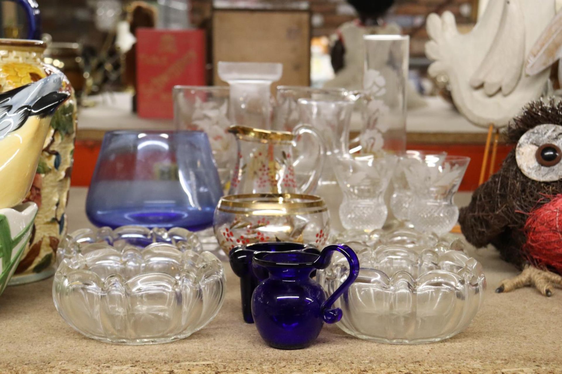 A QUANTITY OF GLASSWARE TO INCLUDE DRINKING GLASSES, BOWLS, JUGS, ETC.,