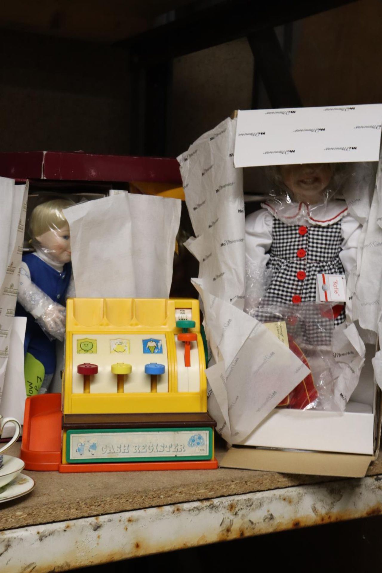 THREE BOXED DOLLS AND A FISHER-PRICE CASH REGISTER