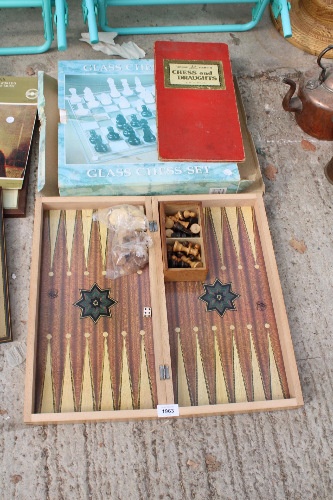 A WOODEN FOLDING CHESS BOARD AND WOODEN CHESS SET AND A FURTHER GLASS CHESS SET